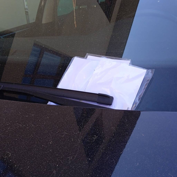 a parking ticket for a car owner for violating parking regulations - Foto, Imagem