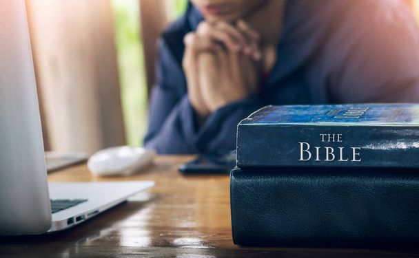 Close up the Bible with a christian man praying in background, pray and worship concept. - Φωτογραφία, εικόνα