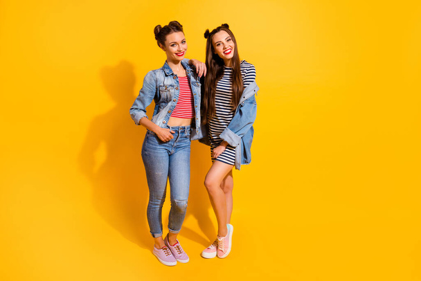 Full size portrait of two lovely satisfied girls embrace toothy smile good mood isolated on yellow color background - Valokuva, kuva