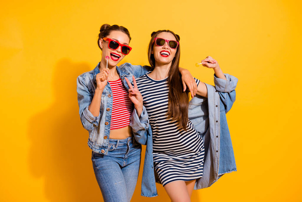 Photo of two carefree cheerful girls have good mood show v-sign isolated on yellow color background - Фото, зображення