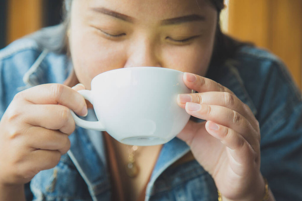 Close up an Asain woman in a casual wear drinking a coffee in a coffee shop - Photo, image