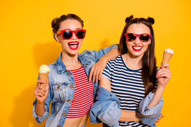 Photo of two excited carefree pretty people hug enjoy ice cream isolated on yellow color background - Фото, зображення