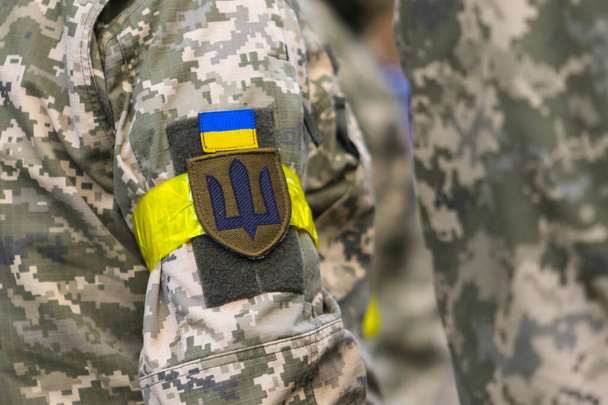 POLTAVA, UKRAINE  18 MAY, 2022: Chevron, yellow headband and Ukrainian flag in the uniform of the Ukrainian military - Zdjęcie, obraz