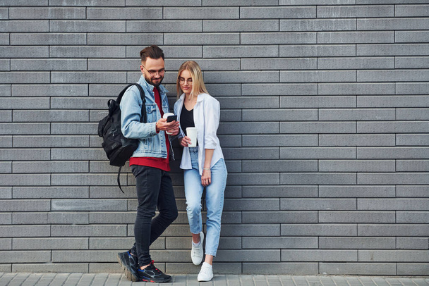 Young stylish man with woman in casual clothes outdoors together. Conception of friendship or relationships. - Foto, imagen