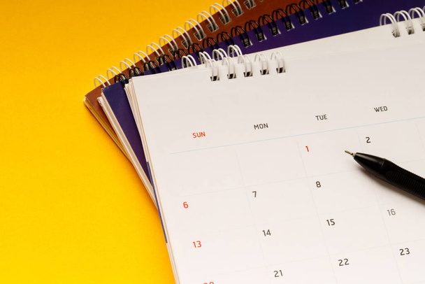 close up top view calendar schedule to make appointment meeting or manage timetable each day lay on yellow background for planning work and travel concept. - Photo, image