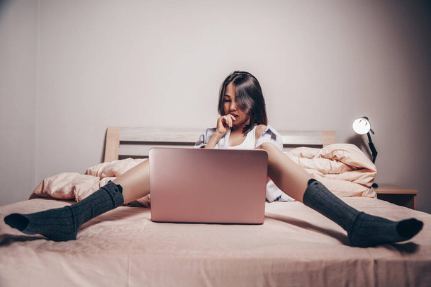 mladý asijský webkamera modelka dívka sedí před notebookem. komunikuje a předvádí svůj šarm. nízká hloubka zaměření, selektivní zaměření - Fotografie, Obrázek