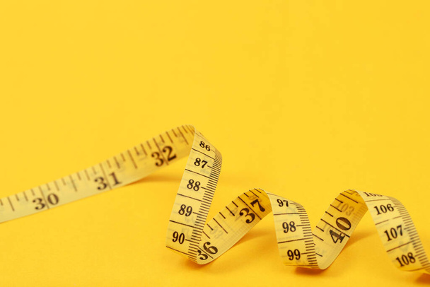 opatření pásky pro obézní lidi na žlutém pozadí měkké zaměření - Fotografie, Obrázek