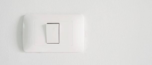 Interruptor electrónico de iluminación con fondo de pared blanco. energía eléctrica doméstica. - Foto, imagen