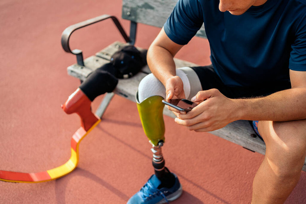 Disabled Young athlete using phone - 写真・画像