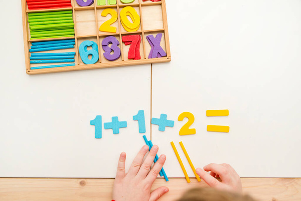 3D wooden numbers. Implement for learning to count with help of digits and "pop it" toy. Addition and subtraction exercises. Mathematical equation for preschool children. - Photo, Image