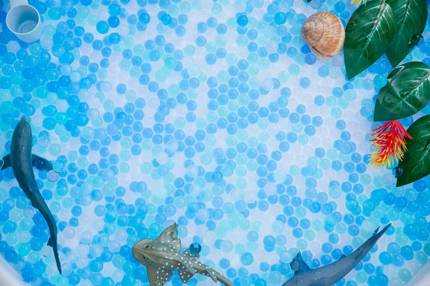 Wassergallerie-Bällebad mit karibischem Fischspielzeug und künstlichen Pflanzen. Sinnessedierung für Kinder und Menschen mit besonderen Bedürfnissen. Entspannungsaktivitäten zuhause. - Foto, Bild