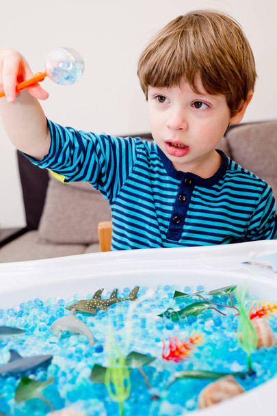 Piscine de boule de gelée d'eau avec les Caraïbes voir les poissons jouets et les plantes artificielles. Sédation sensorielle pour les enfants et les personnes ayant des besoins spéciaux. Activités de détente à la maison. - Photo, image