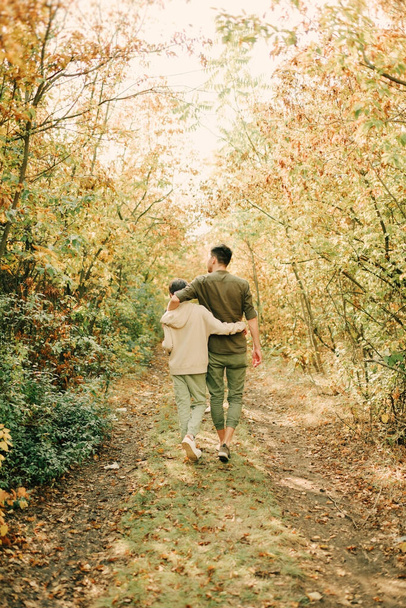 dad and son hugging walking in the autumn forest - Φωτογραφία, εικόνα