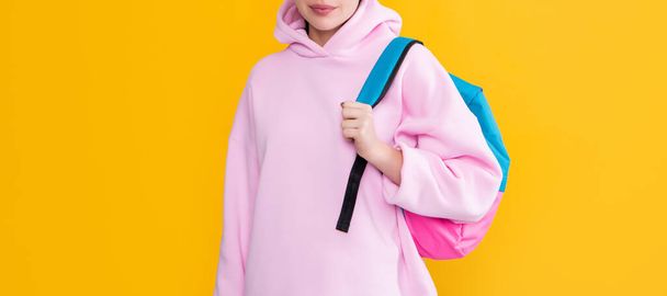 cheerful student girl in headphones with backpack on yellow background - Фото, зображення