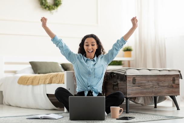 Жінка, використовуючи ноутбук, що святкує успіх, трясе кулаками кричачи так
 - Фото, зображення