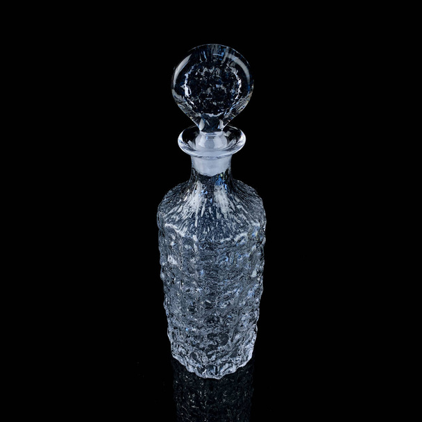 antique crystal decanter with engraving. vintage decanter for alcoholic beverages on a black isolated background - 写真・画像