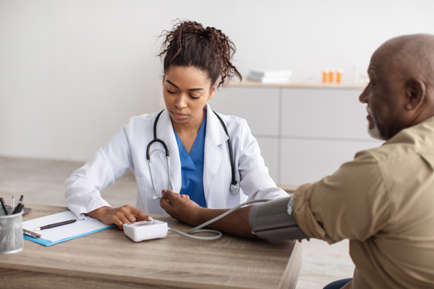 Schwarze Ärztin überprüft Druck auf Patientenhand - Foto, Bild