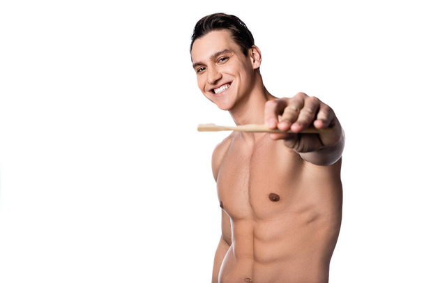 ευχαριστημένος άνθρωπος με τέλειο σώμα δείχνει οδοντόβουρτσα απομονώνονται σε λευκό - Φωτογραφία, εικόνα