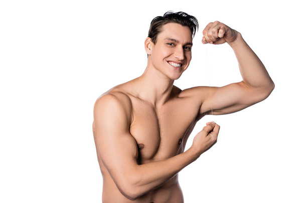 cheerful shirtless man posing with dental floss isolated on white - Fotó, kép