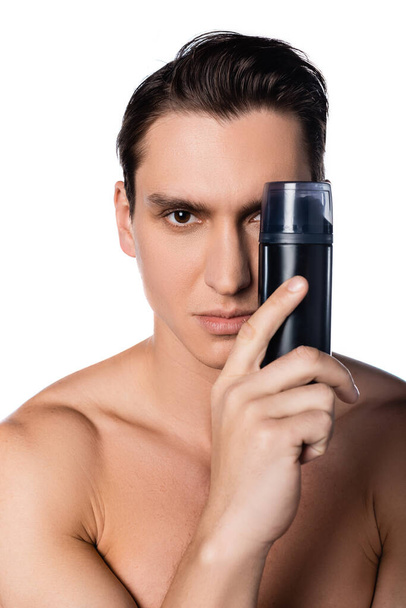 man with naked shoulders holding antiperspirant near face isolated on white - Fotó, kép
