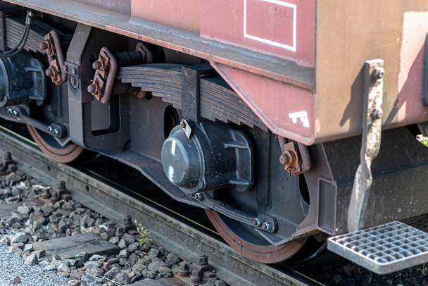 Steel wheels of a freight car running on rails, visible semi-elliptical springs. - Foto, Imagem