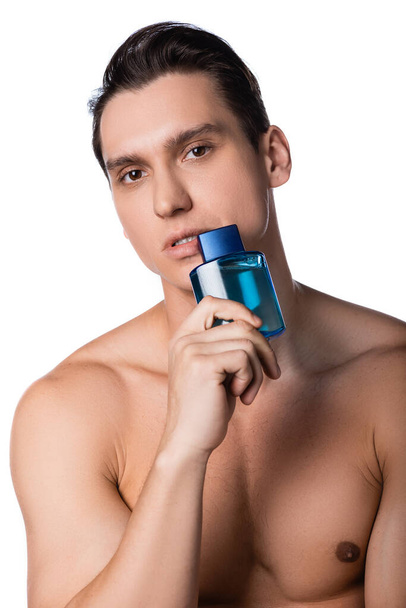 Göğsünde parfüm şişesi tutan çıplak bir adam. Yüzüne yakın bir yerde. - Fotoğraf, Görsel