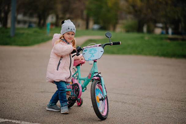Girl with her first bicycle - Фото, изображение