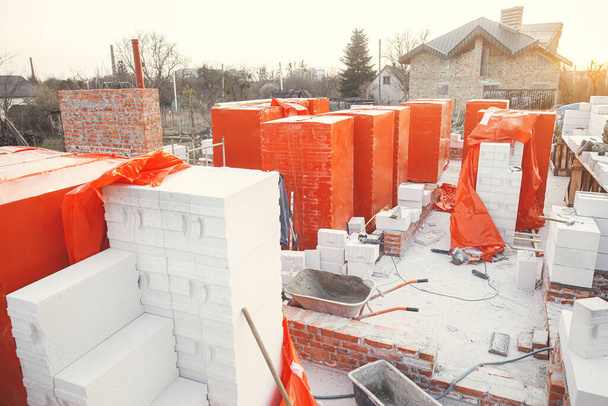Building materials at construction site. Autoclaved aerated blocks on concrete foundation, process of house building. Stacks of white aerated blocks for laying on concrete foundation. - Zdjęcie, obraz