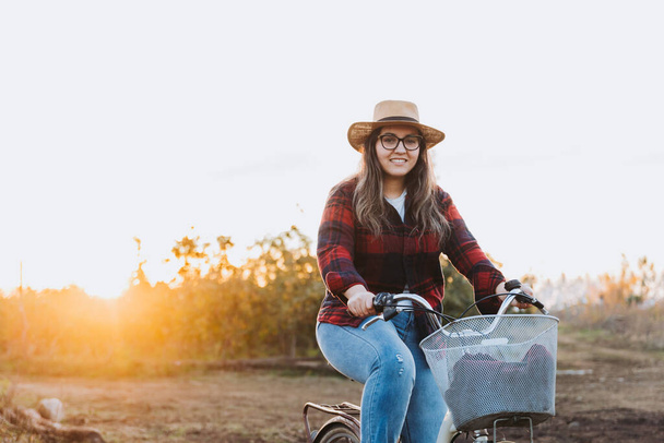 Latynoska farmerka jeżdżąca na rowerze na środku swojej farmy. Trwały transport. - Zdjęcie, obraz