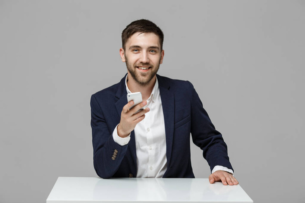 Obchodní koncept - portrét pohledný obchodní muž hraje telefon s úsměvem a jistý tvář. Bílé Background.Copy prostor. - Fotografie, Obrázek