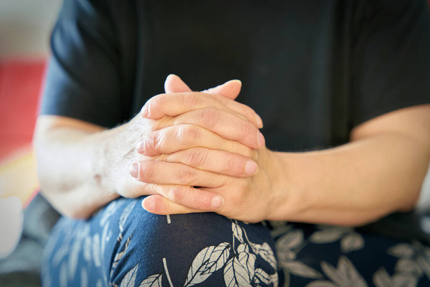 Жінка зі складеними руками сидить розслабленою і слухає розмову
                                - Фото, зображення