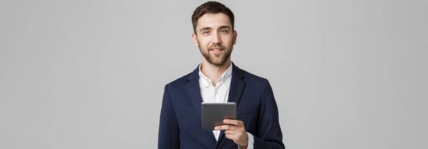 Üzleti koncepció - portré jóképű üzleti ember játszik digitális tabletta-val magabiztos arc mosolyog. Fehér háttér. Másolja a hely. - Fotó, kép