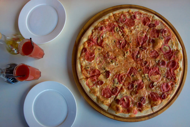 Velká pizza na bílém stole v kavárně - Fotografie, Obrázek