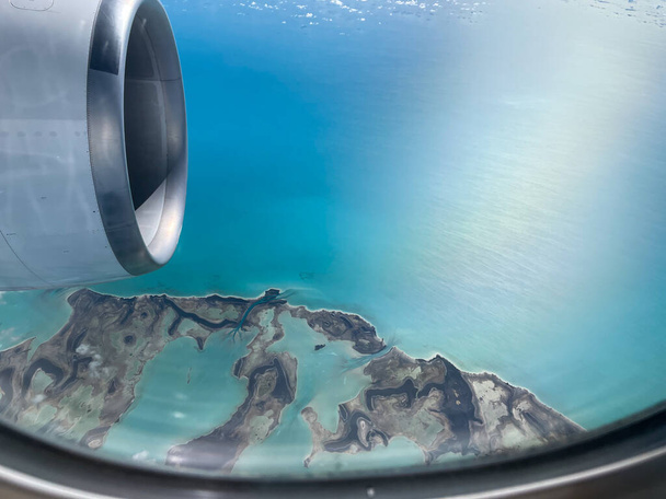 view from the window of an airplane. turbine of an airplane under the caribbean. Clear sea water and islands in the background. - Foto, imagen