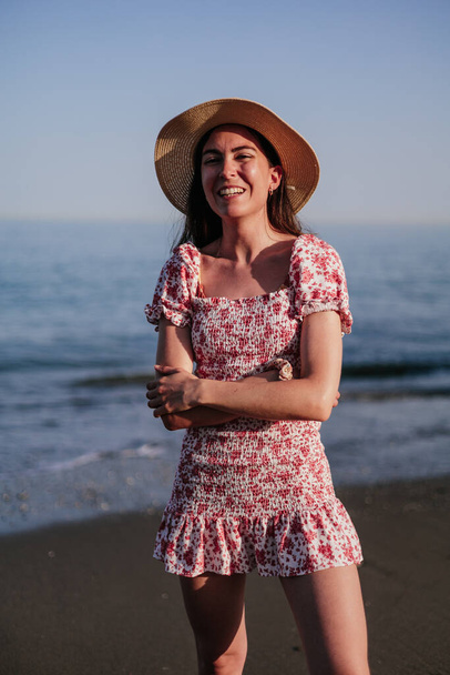 Retrato de una hermosa joven con sombrero de ala ancha en la playa al atardecer
 - Foto, Imagen