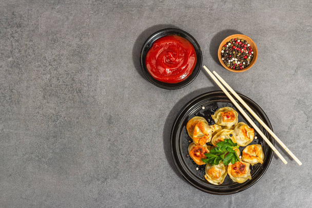 Deep-fried dumplings with tomato sauce and pepper mix. Trendy vegan food, modern hard light, dark shadow. Stone concrete background, top view - Foto, Imagem