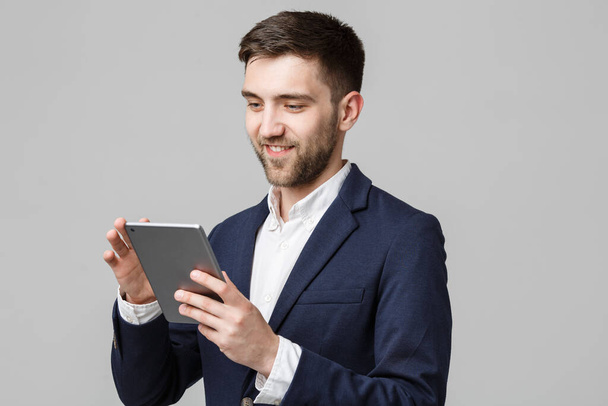Conceito de negócio - Retrato Bonito homem de negócios jogando tablet digital com rosto confiante sorridente. Fundo branco.Espaço de cópia
. - Foto, Imagem