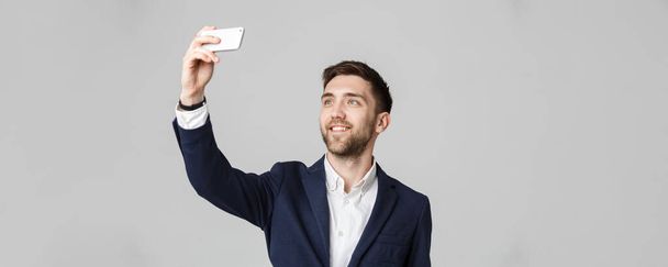 Conceito de negócio - Bonito homem de negócios tirar uma selfie de si mesmo com smartphone. Fundo branco
. - Foto, Imagem