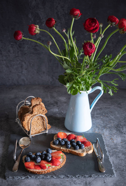 sandwiches with croutons and fresh strawberries and blueberries on a dark  - Foto, afbeelding