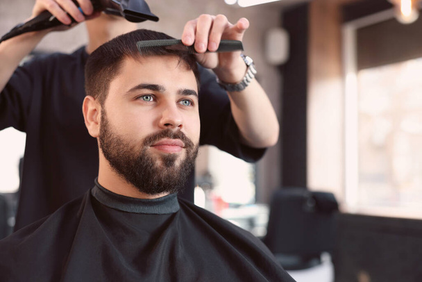 Professional hairdresser working with client in barbershop - Zdjęcie, obraz