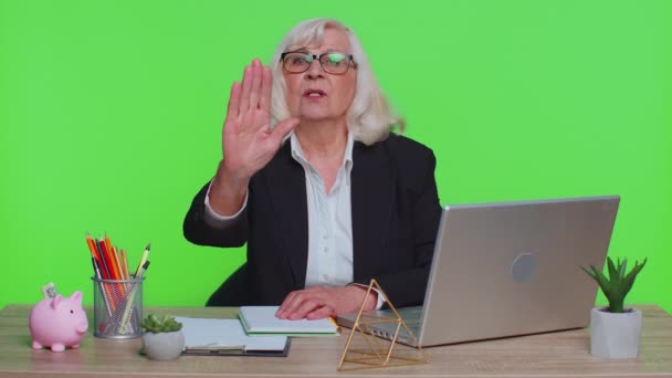 Senior businesswoman say no hold palm hand in stop gesture, warning of prohibited access danger - Footage, Video