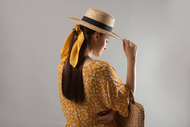 Woman with hat and stylish yellow bandana on light grey background - Zdjęcie, obraz