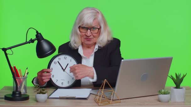 Senior smiling businesswoman showing time on wall office clock, ok, thumb up, good approve success - Filmati, video