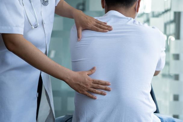 Uzun erkek hastalar için kiropraktik kemik tedavisi fizyoterapisi hastanın sırt ağrısı tedavisi doktor masör ofisi sendromu - Fotoğraf, Görsel