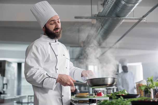 Esperto di gastronomia indossa uniforme di cottura durante la cottura delizioso piatto gourmet per il servizio di cena. - Foto, immagini