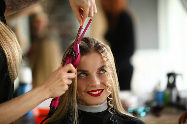 Blond vrouw op kapper afspraak, meester creëren krullend kapsel - Foto, afbeelding