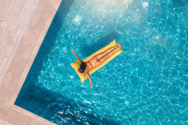 Girl in swimsuit who tan in a swimming pool - Foto, immagini