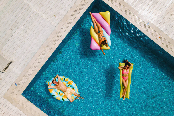 Amigos de maiô na piscina ficando bronzeado - Foto, Imagem