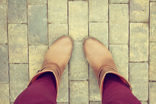 Sapatos castanhos da vista aérea no pavimento bloco de concreto
 - Foto, Imagem