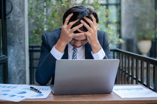 Pracující asijští muži cítí stres, unavený z práce, migréna bolesti hlavy z tvrdé práce při práci v kanceláři. - Fotografie, Obrázek